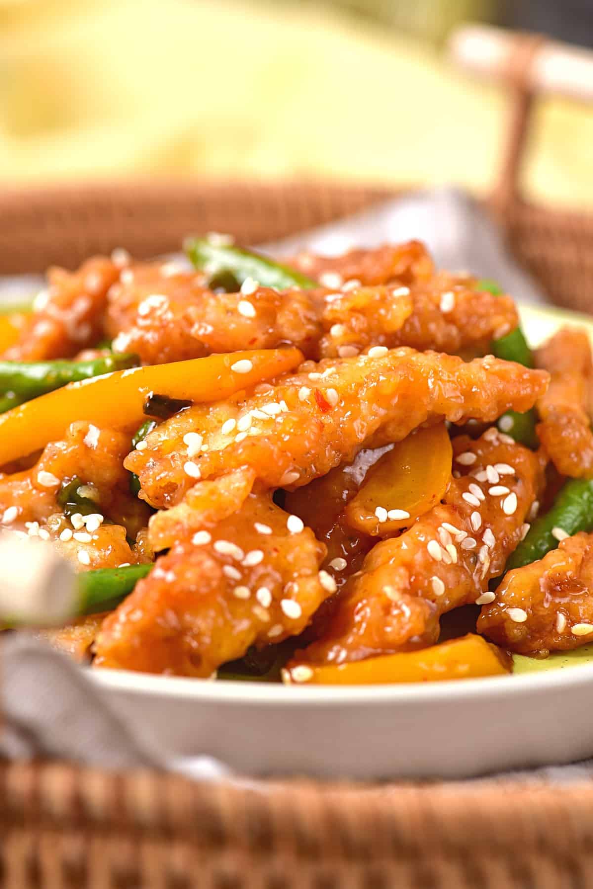 A plate of honey sesame chicken in wicker basket.