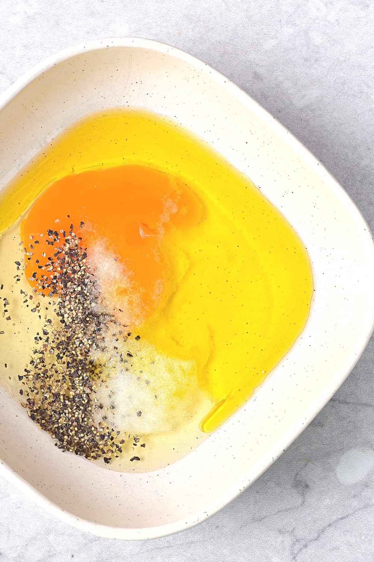 Eggs, oil and condiments in white bowl.