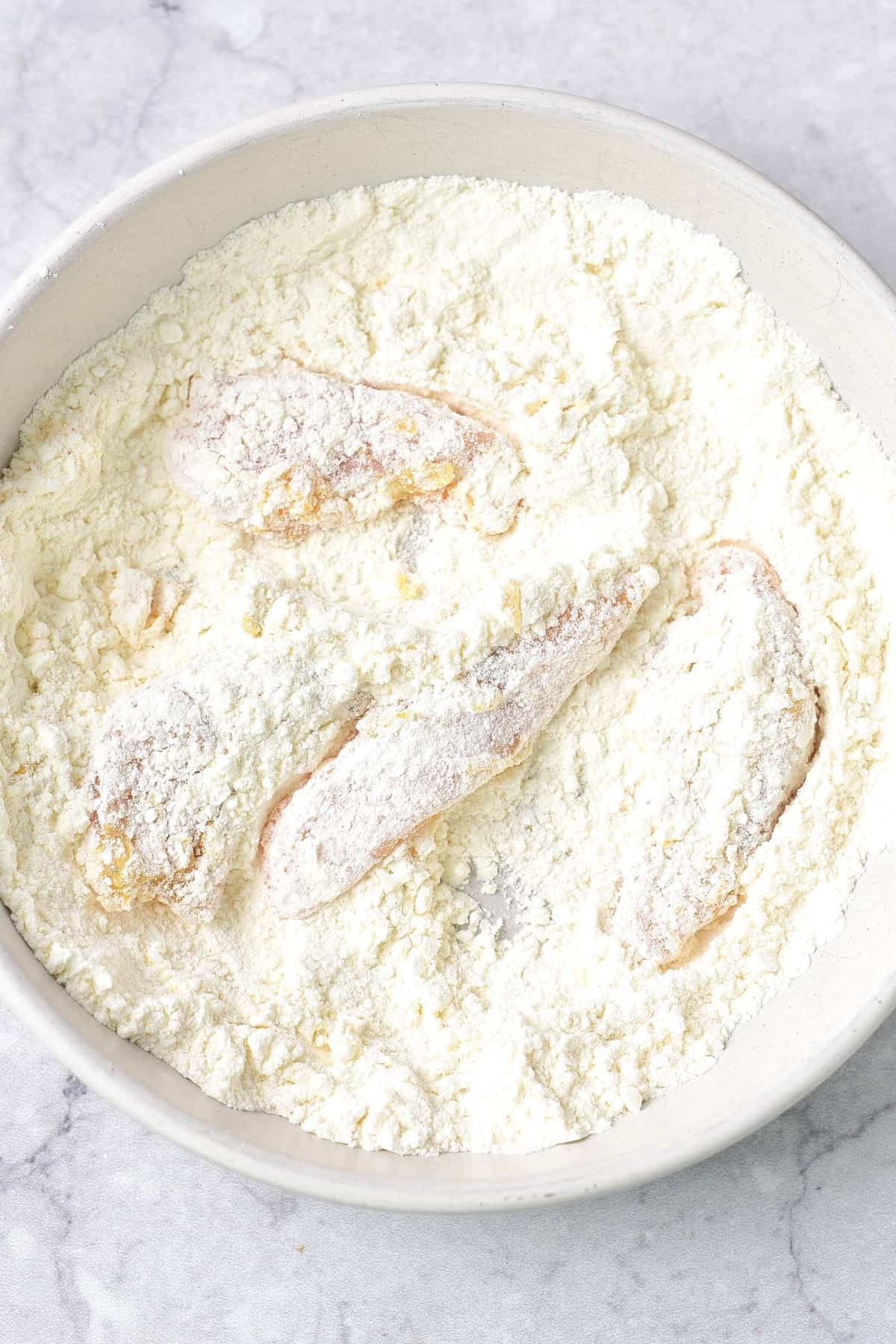 Coating chicken strips in flour mixture