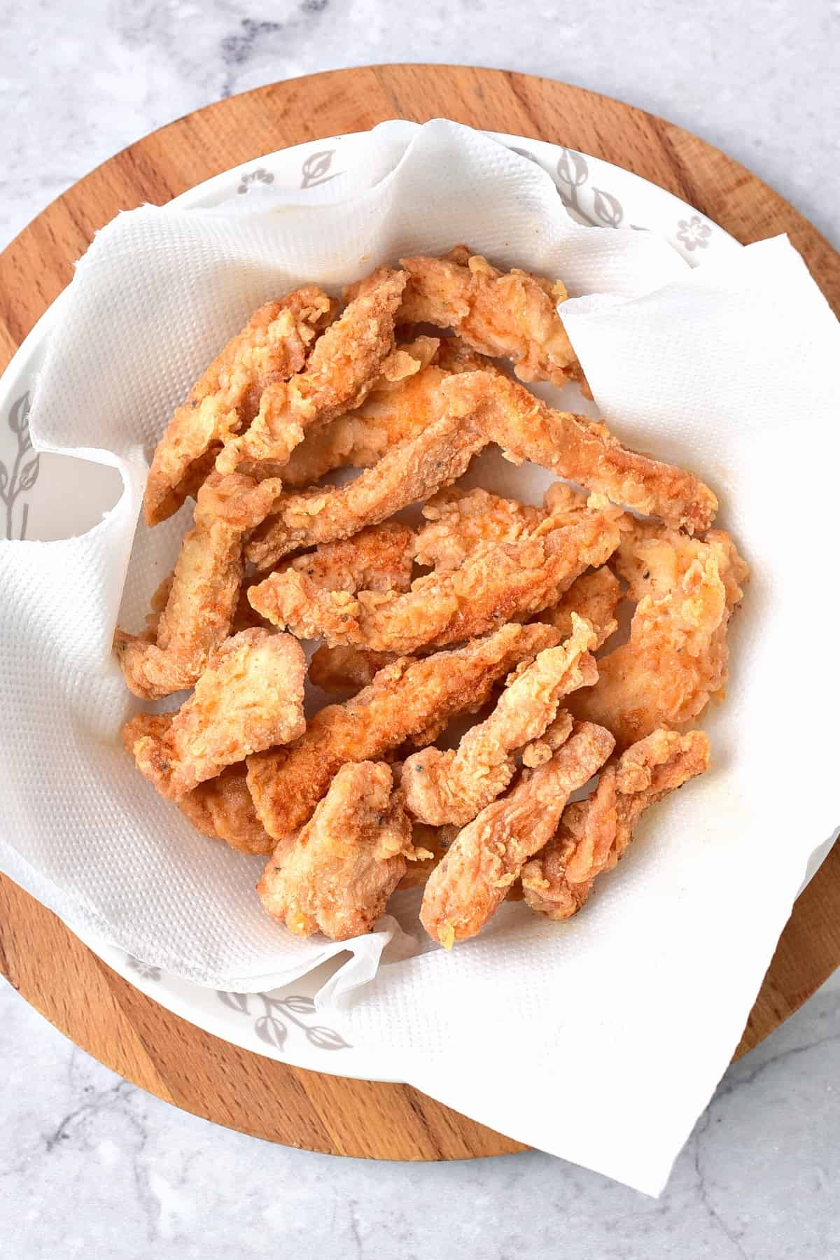 Fried chicken strips on napkin-lined bowl