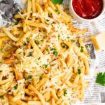 Top down view of truffle fries sprinkled with parsley and parmesan cheese.