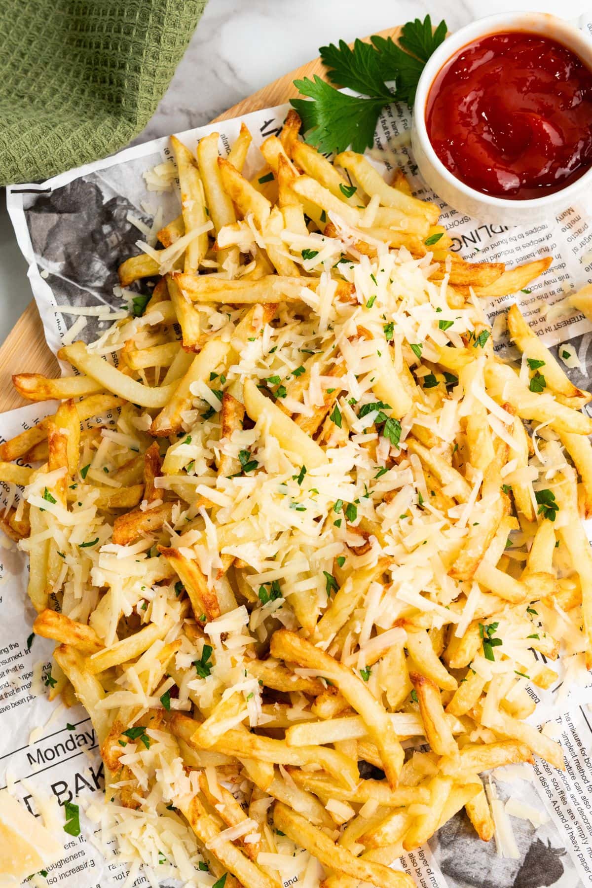 Top down view of parmesan truffle fries on paper.