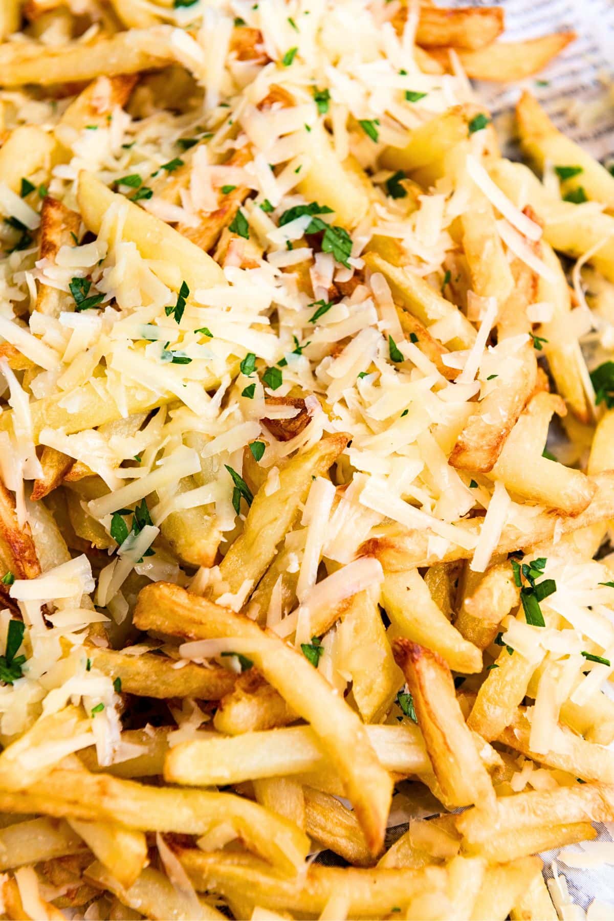 Up close view of truffle parmesan fries topped with parsley and shredded parmesan