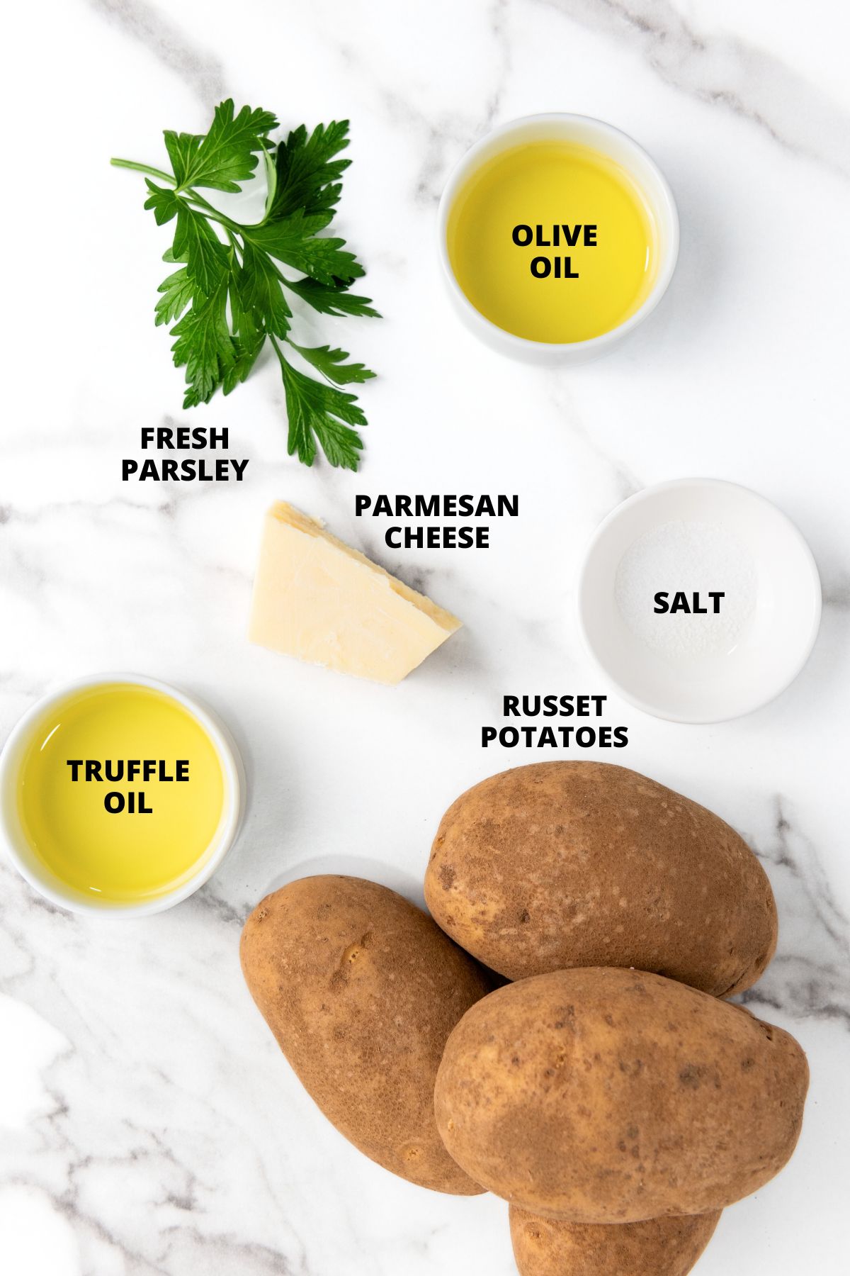 Ingredients for parmesan truffle fries recipe laid out on marble board.