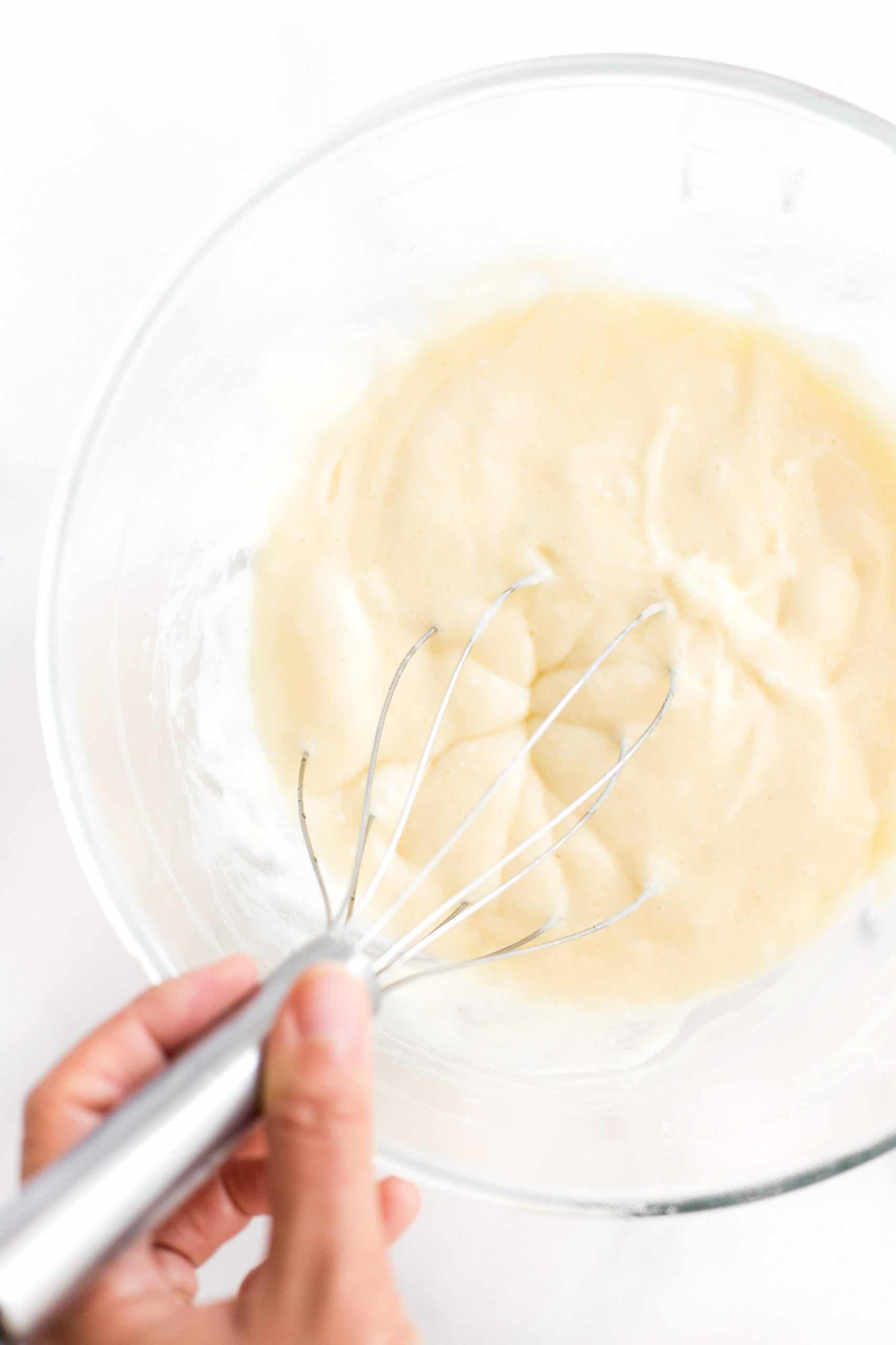Whisking batter in a glass bowl.