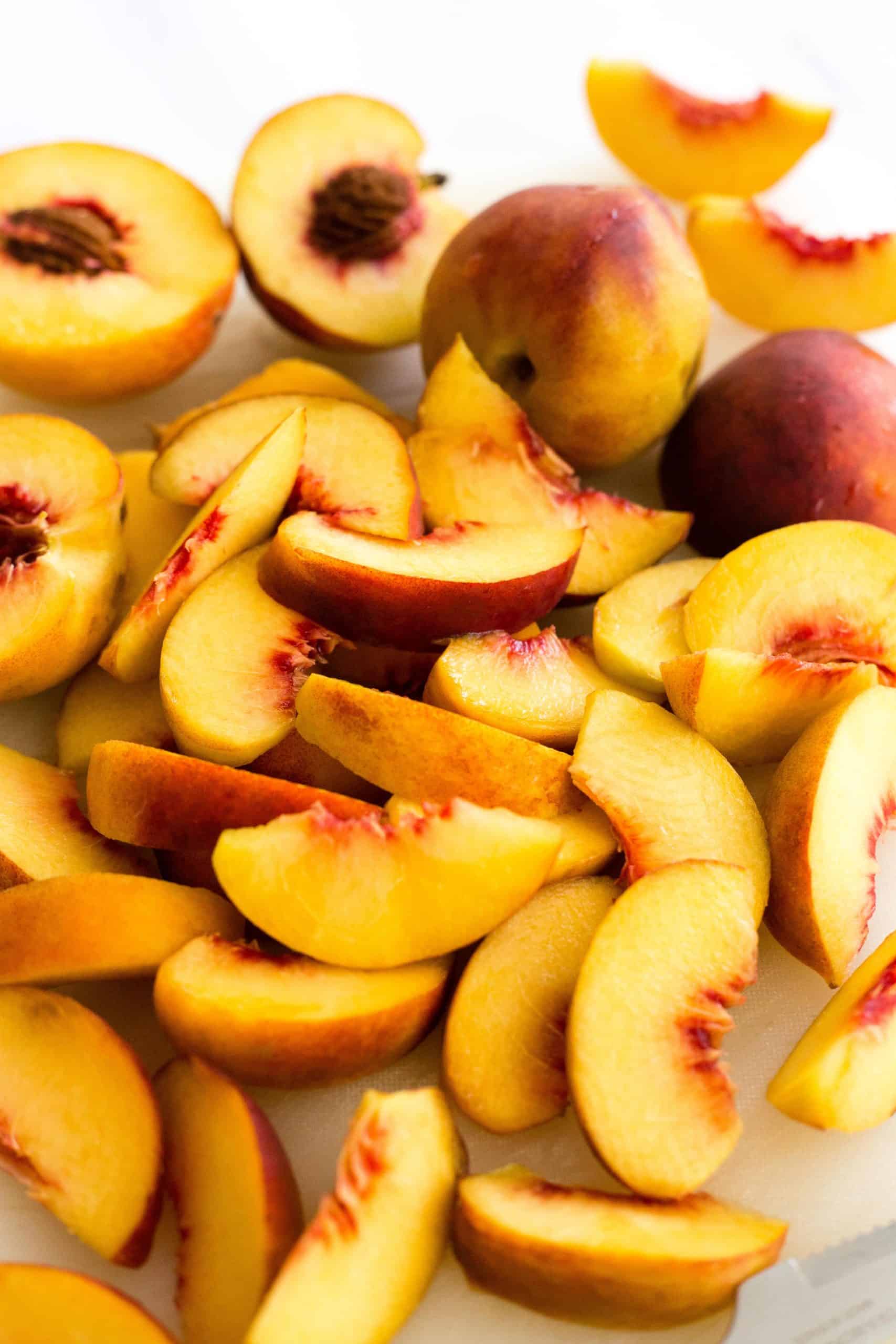 Sliced ripe peaches on a cutting board.