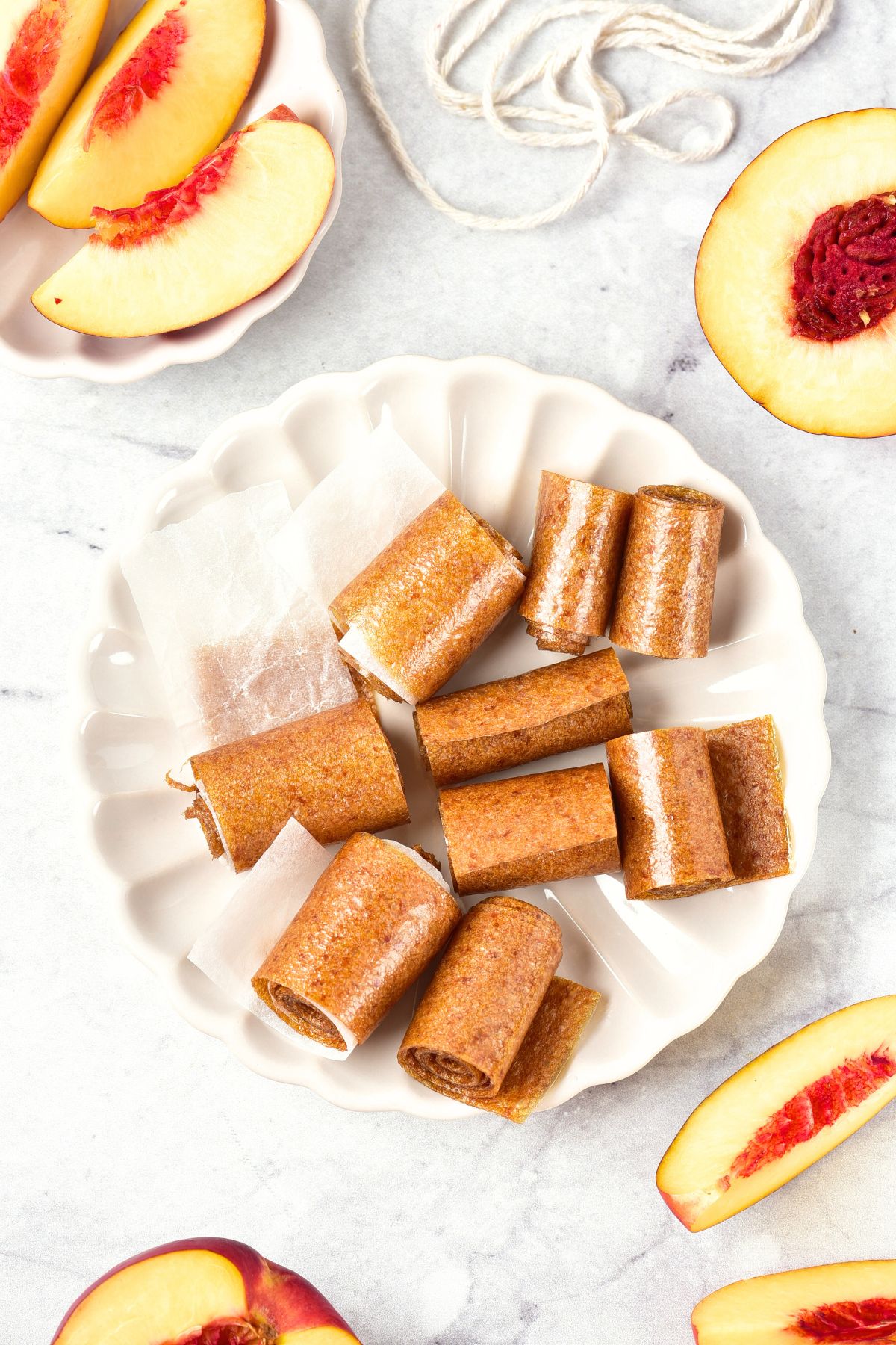 Top down view of rolls of peach leather on white plate