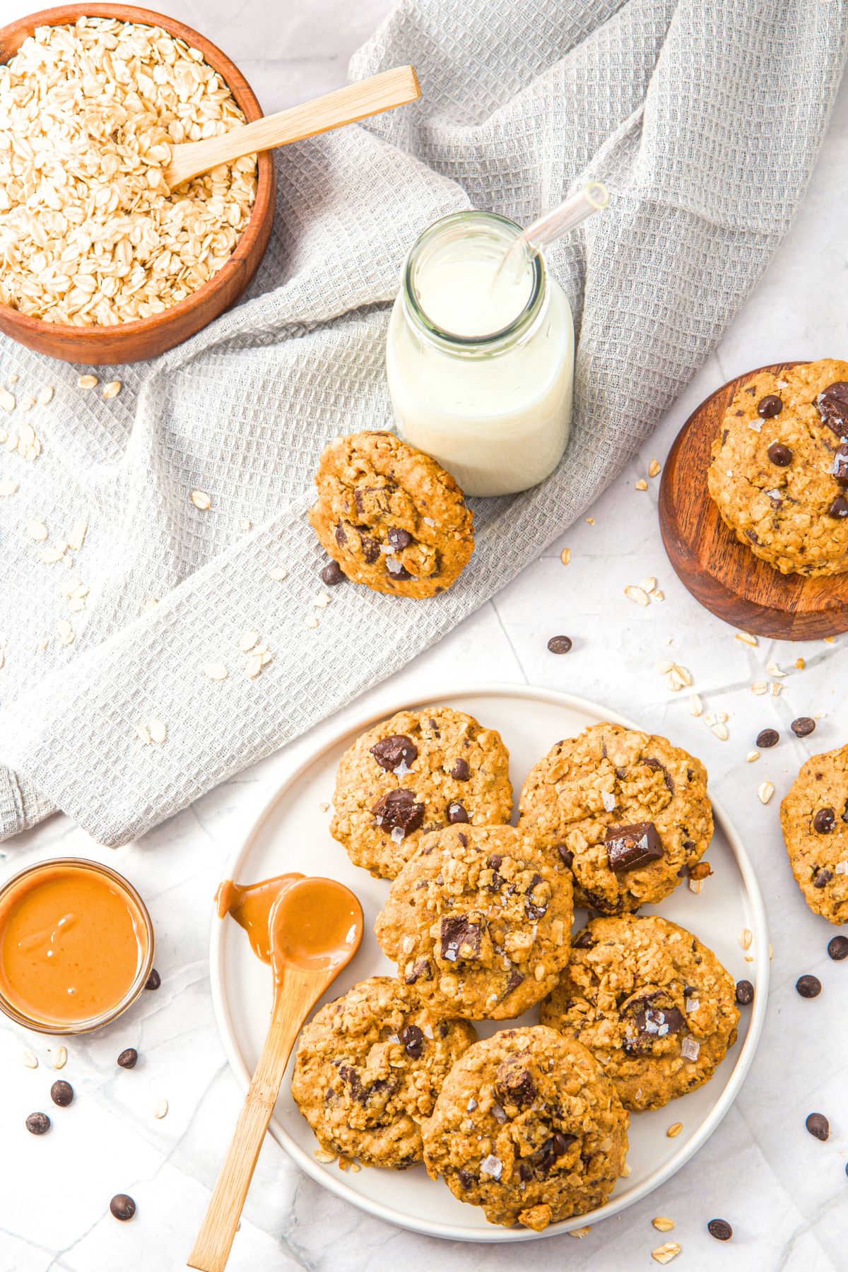 A plate of oatmeal peanut butter cookies with a spoon of peanut butter