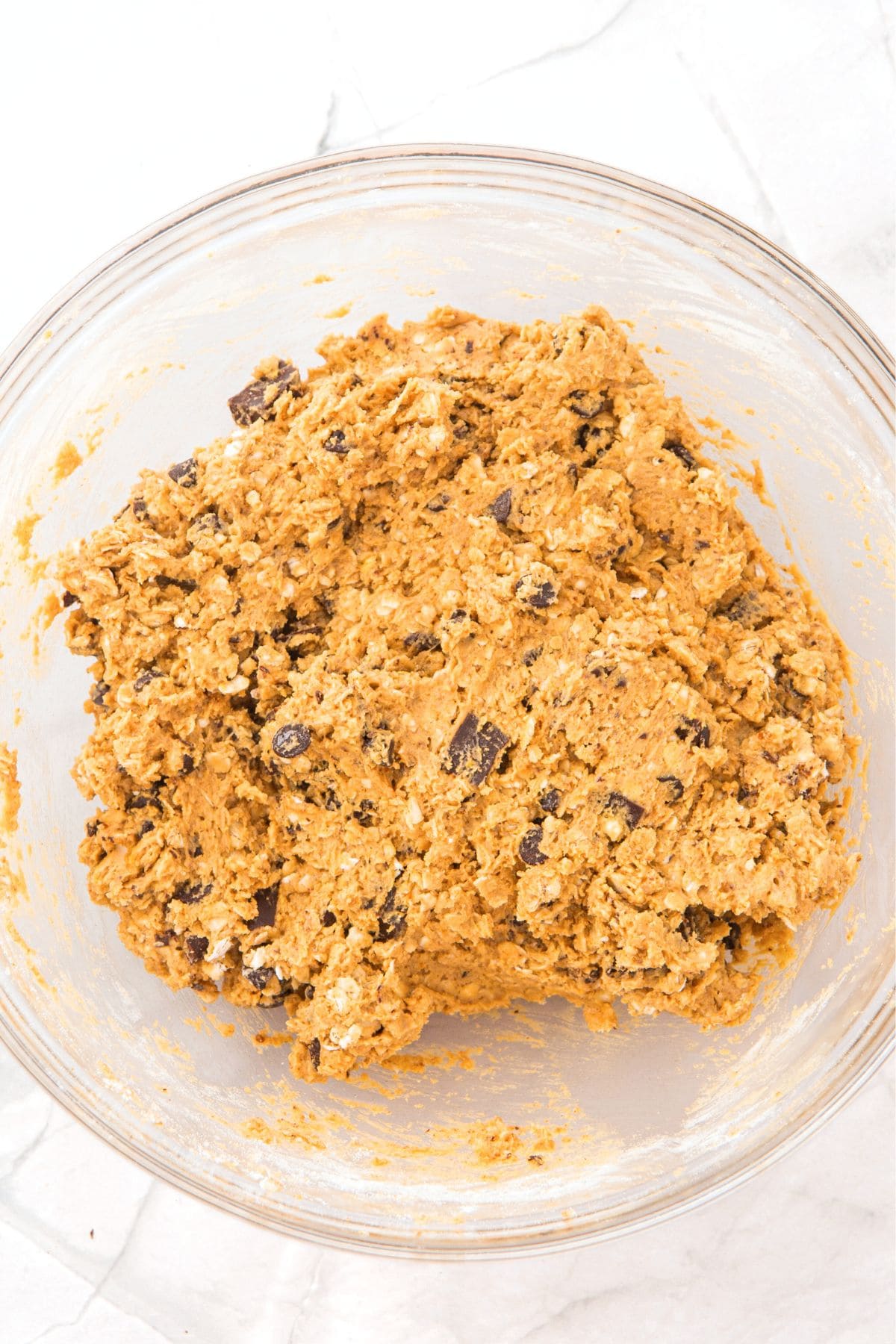 Chocolate chip cookie dough mixture in glass bowl