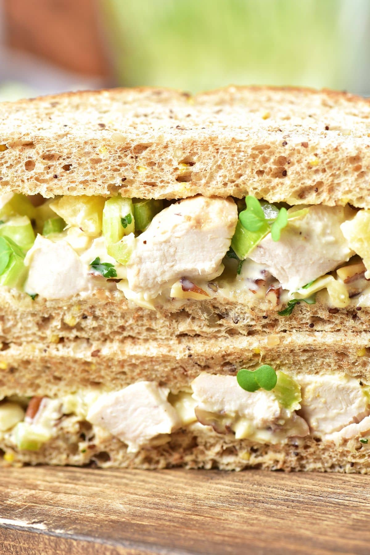 Chicken salad sandwich on wooden board.