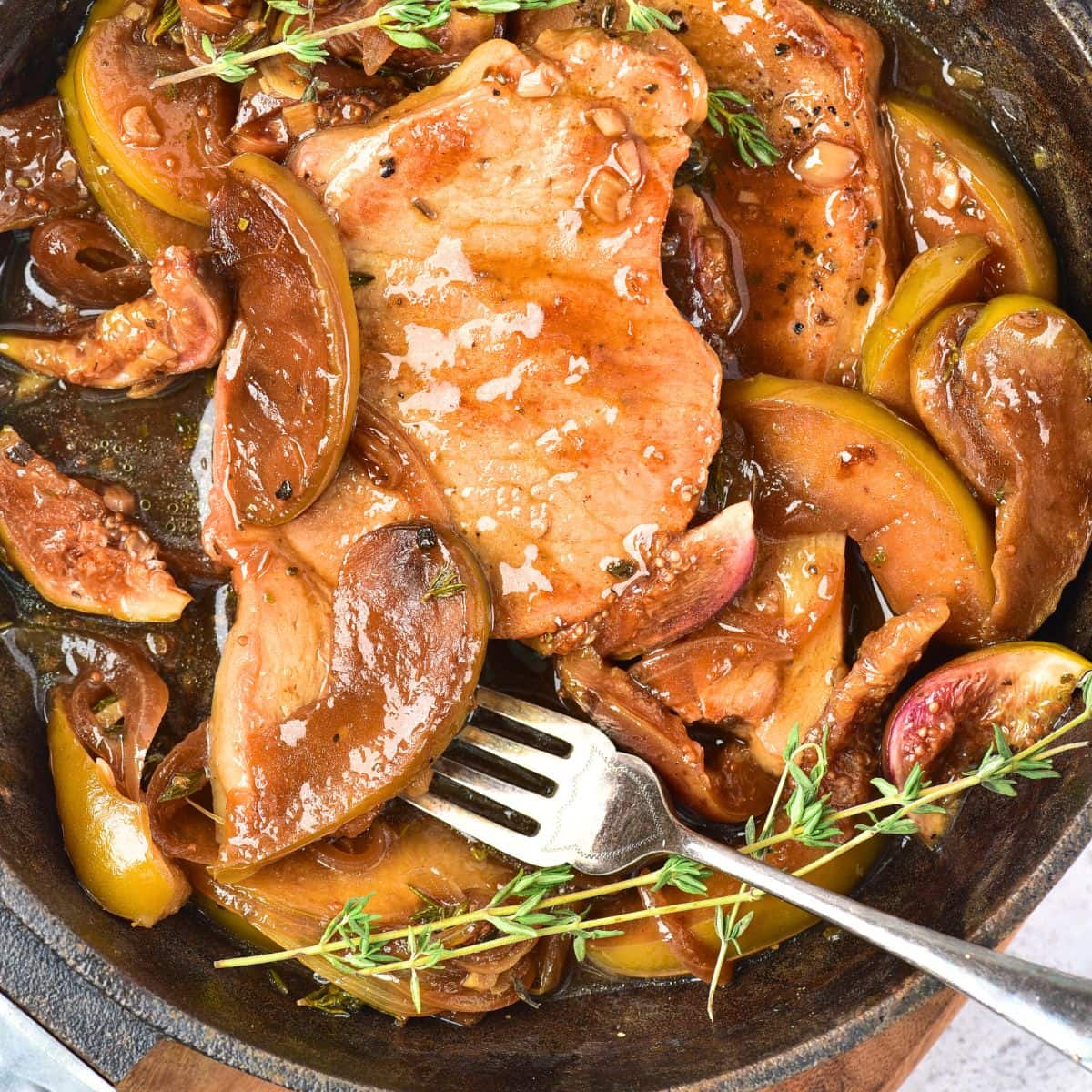 Top down view of skillet with pork chops and apples