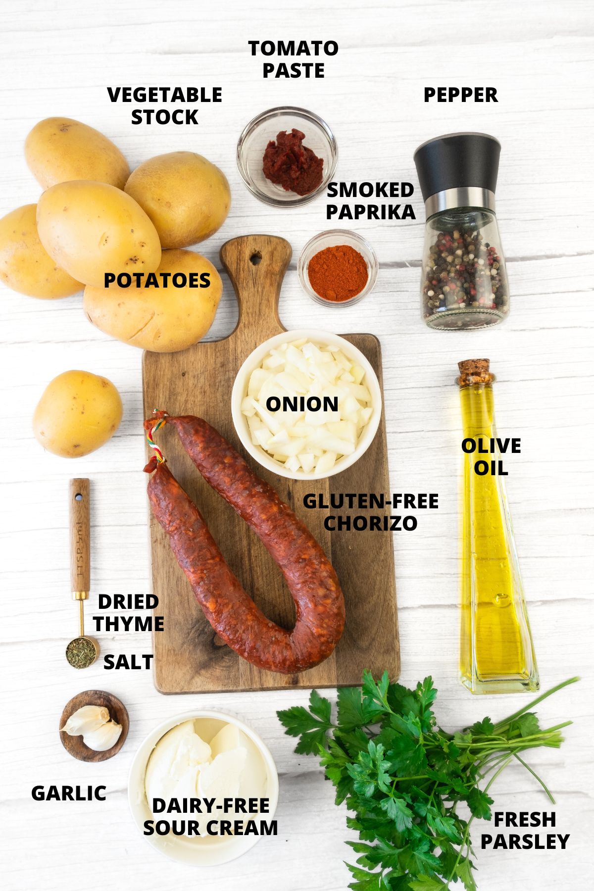 Ingredients for potato chorizo soup recipe laid out on wooden board.