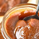 Holding up a spoonful of pumpkin apple butter from jar
