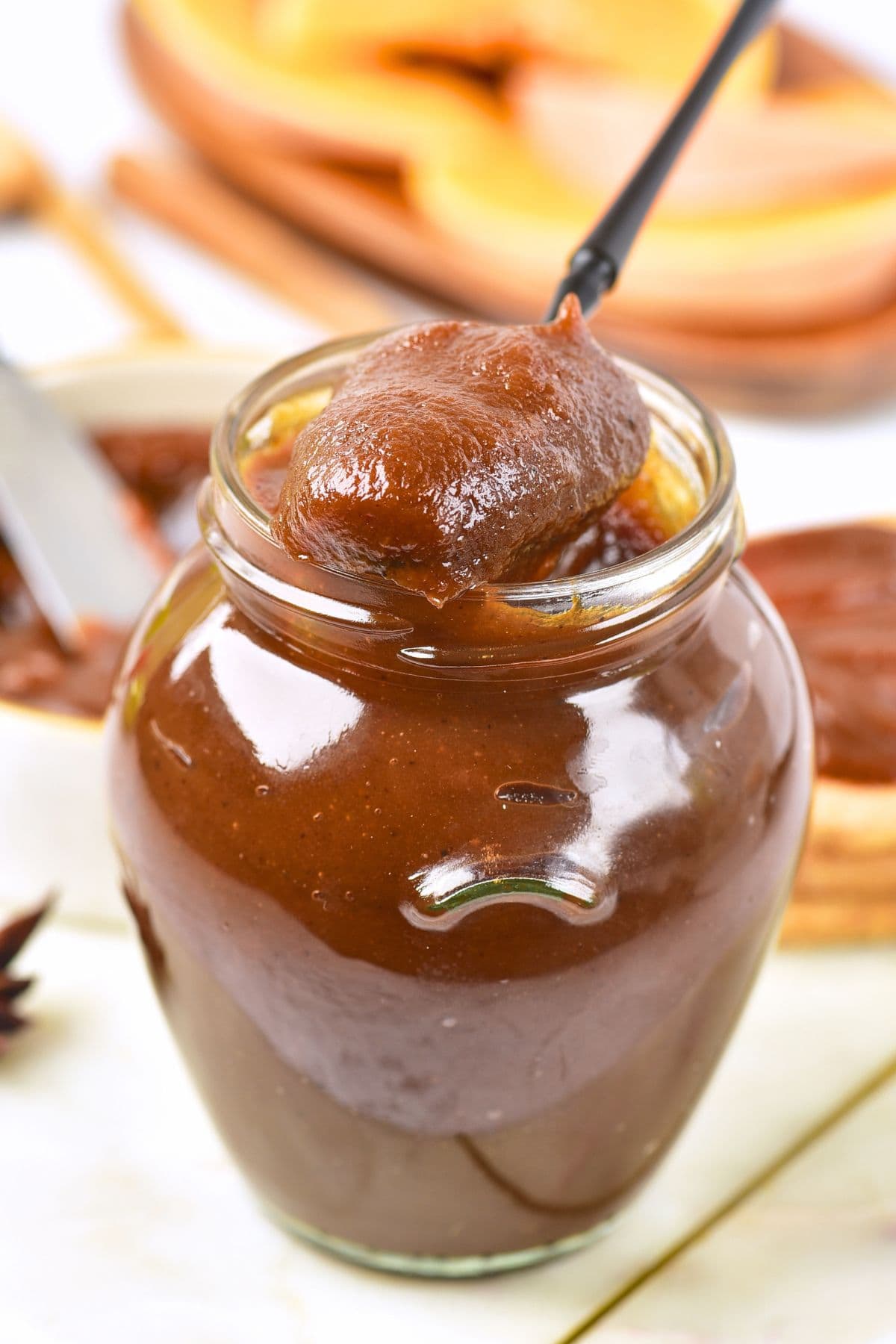 Pumpkin Apple Butter (Gluten-Free, Vegan) Holding up a spoonful of pumpkin apple butter from a jar