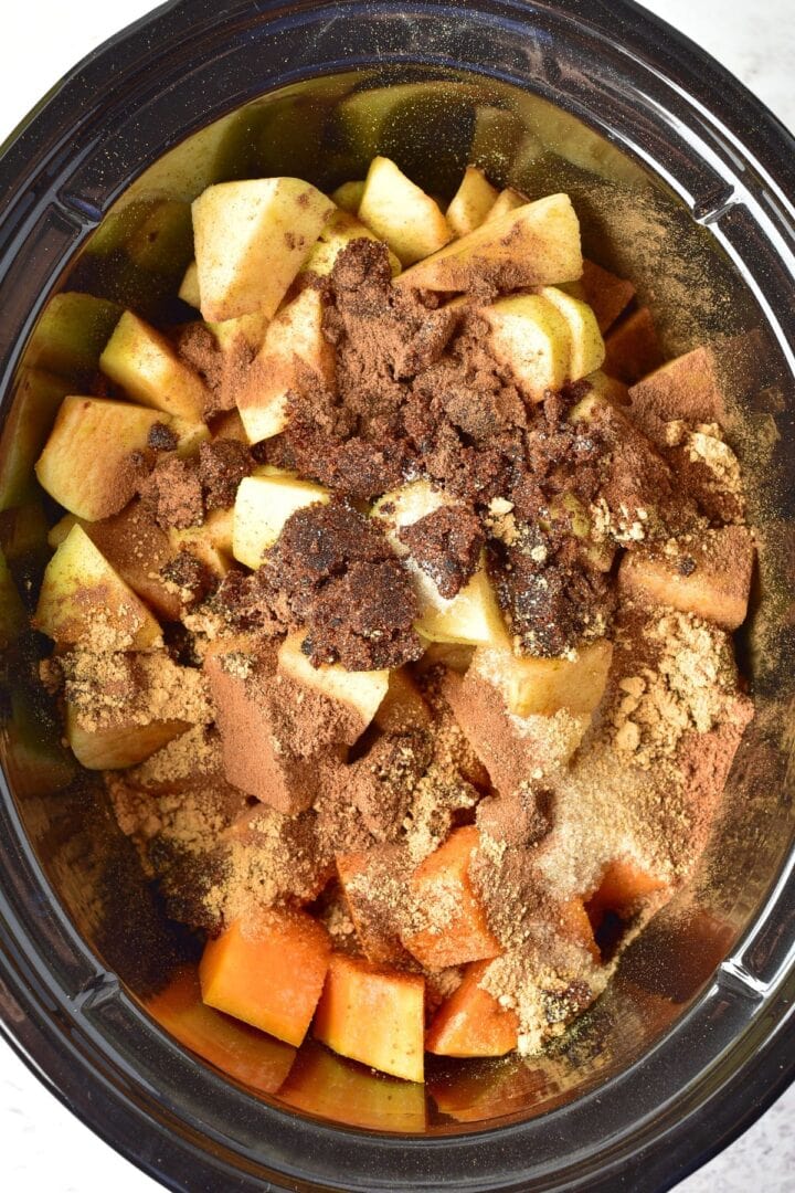 Cubed pumpkin, diced apples, and spices in slow cooker.