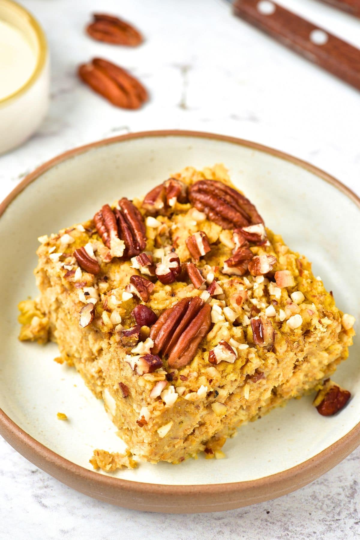 A plate with gluten-free pumpkin baked oatmeal topped with pecans