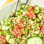 Up close view of a bowl of quinoa tabbouleh topped with cucumber slices