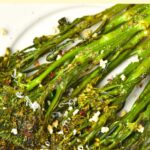 Up close view of roasted broccolini on white plate