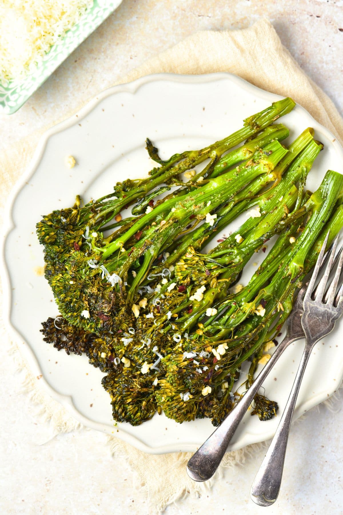 A plate of garlic broccolini on kitchen towel