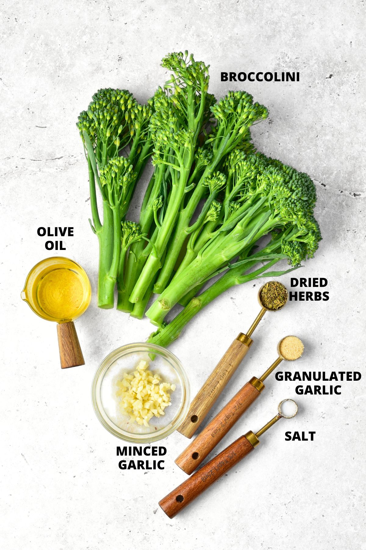 Ingredients for roasted garlic broccolini recipe laid out on white board