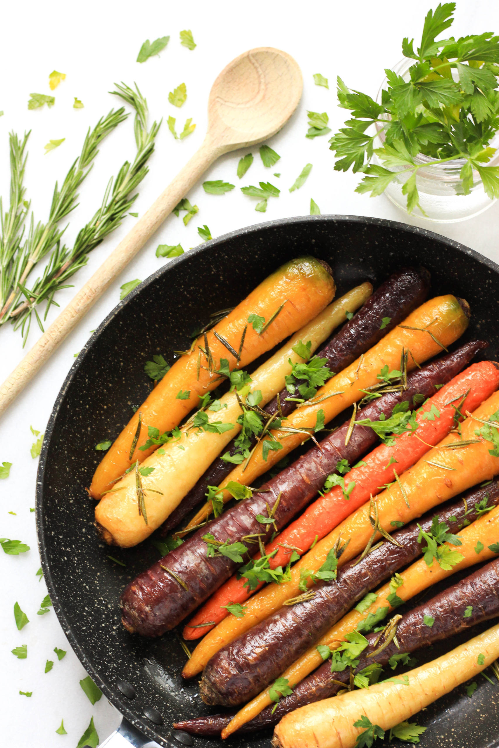 Rainbow carrots garnished with fresh herbs.