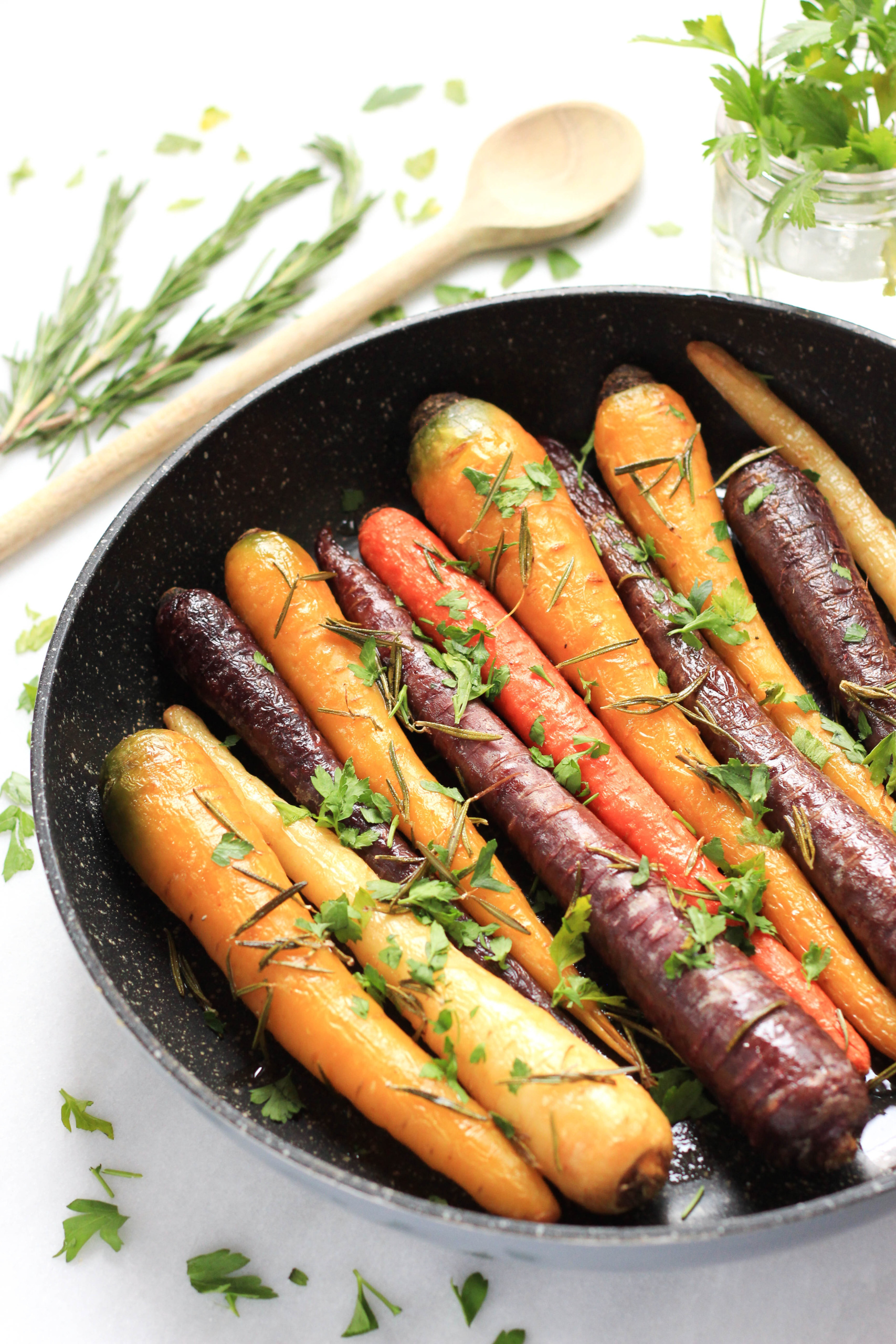 Colorful baked rainbow carrots in a skillet.