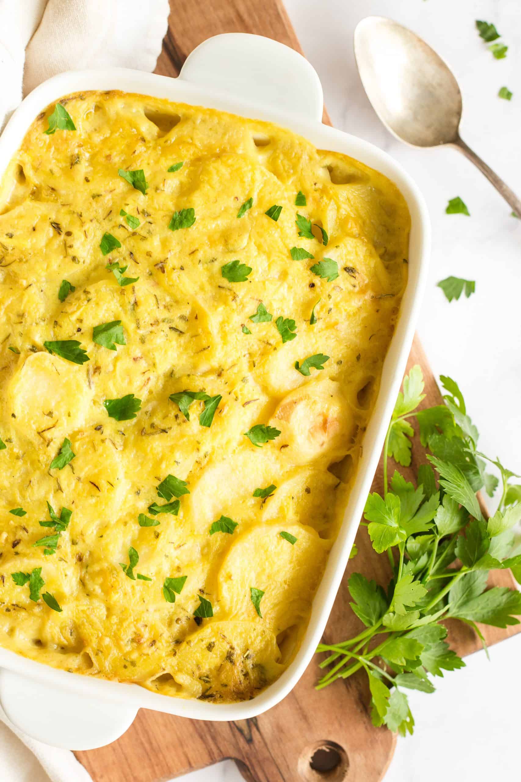 Creamy scalloped potatoes on a wooden board.