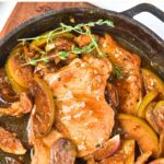 Top down view of a skillet with pork chops and caramelized apples.