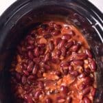Top down view of baked beans in slow cooker.