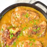A skillet with smothered chicken thighs