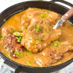 Smothered chicken thighs in cast iron skillet