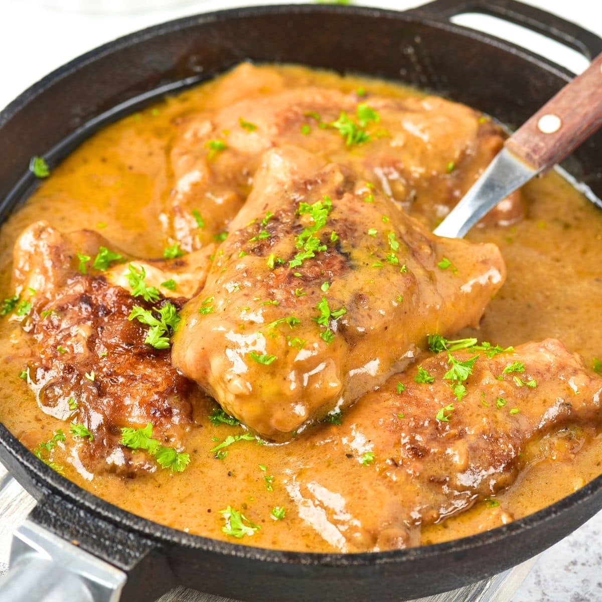 Smothered chicken thighs in cast iron skillet