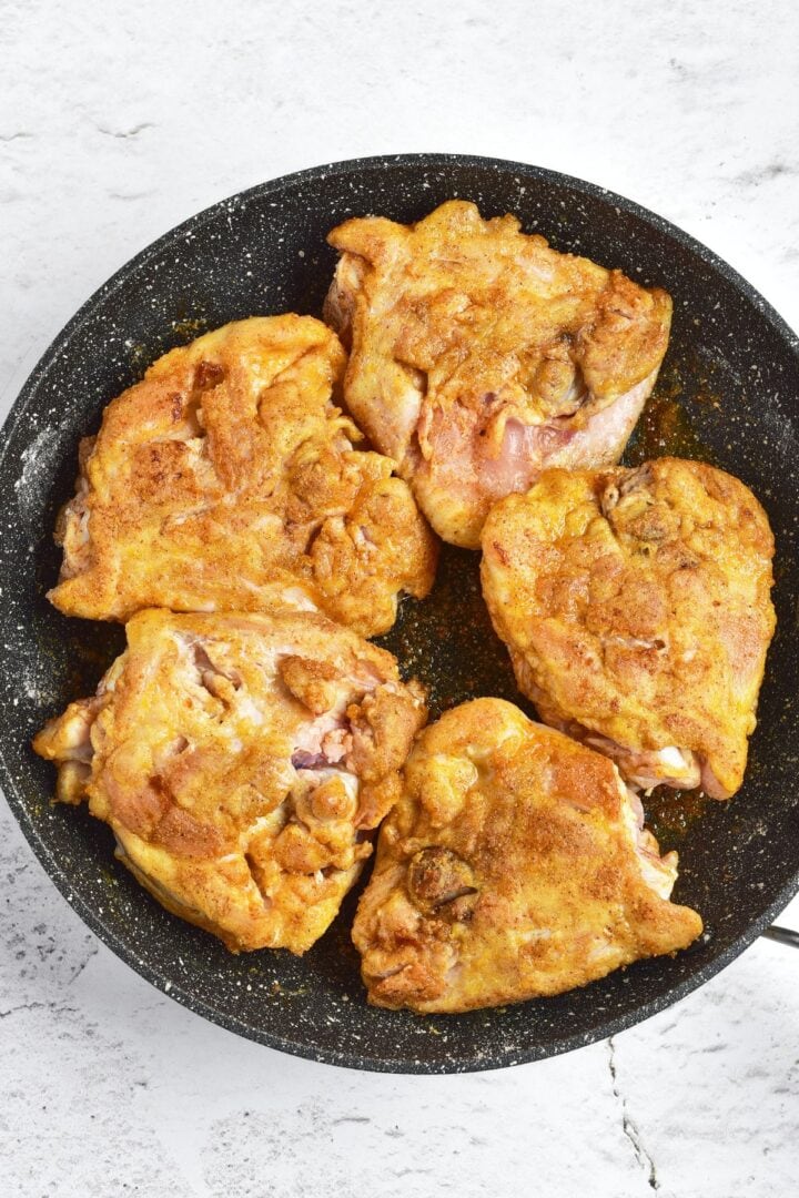 Searing flour-coated chicken thighs in skillet