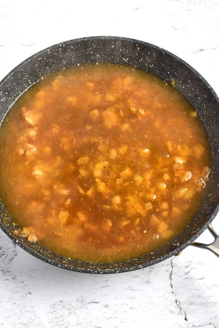 Chicken broth and caramelized onions in skillet