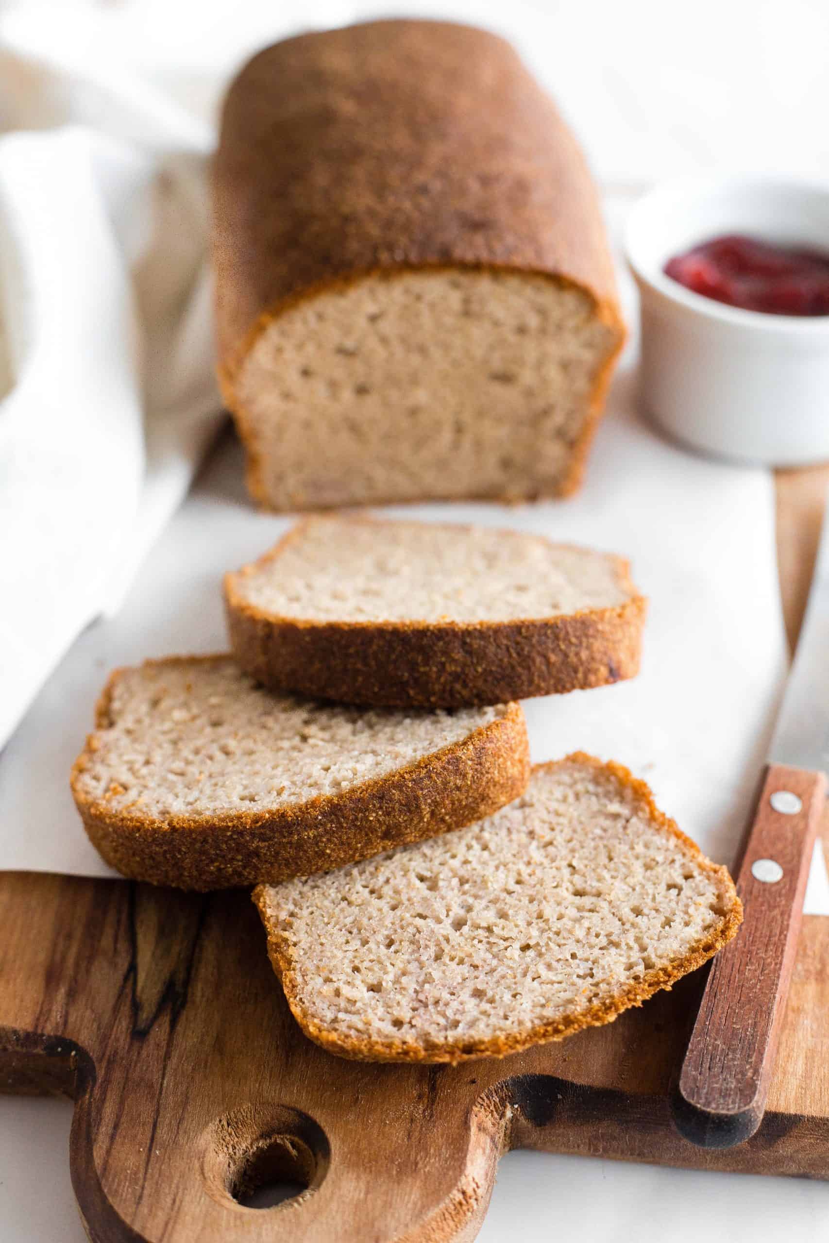 Sliced loaf of bread on parchment-lined board.