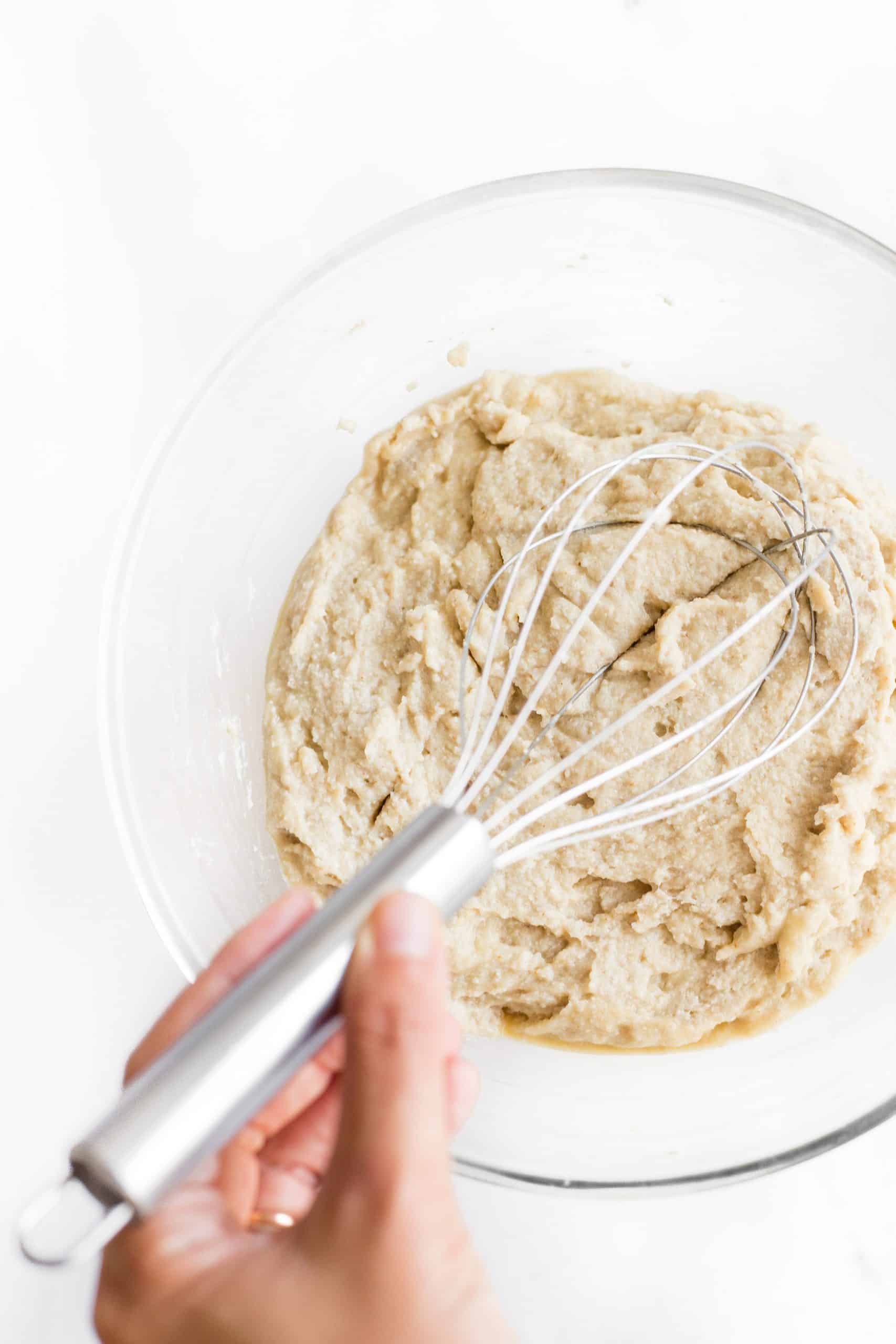 Mixing bread dough in a glass bowl.