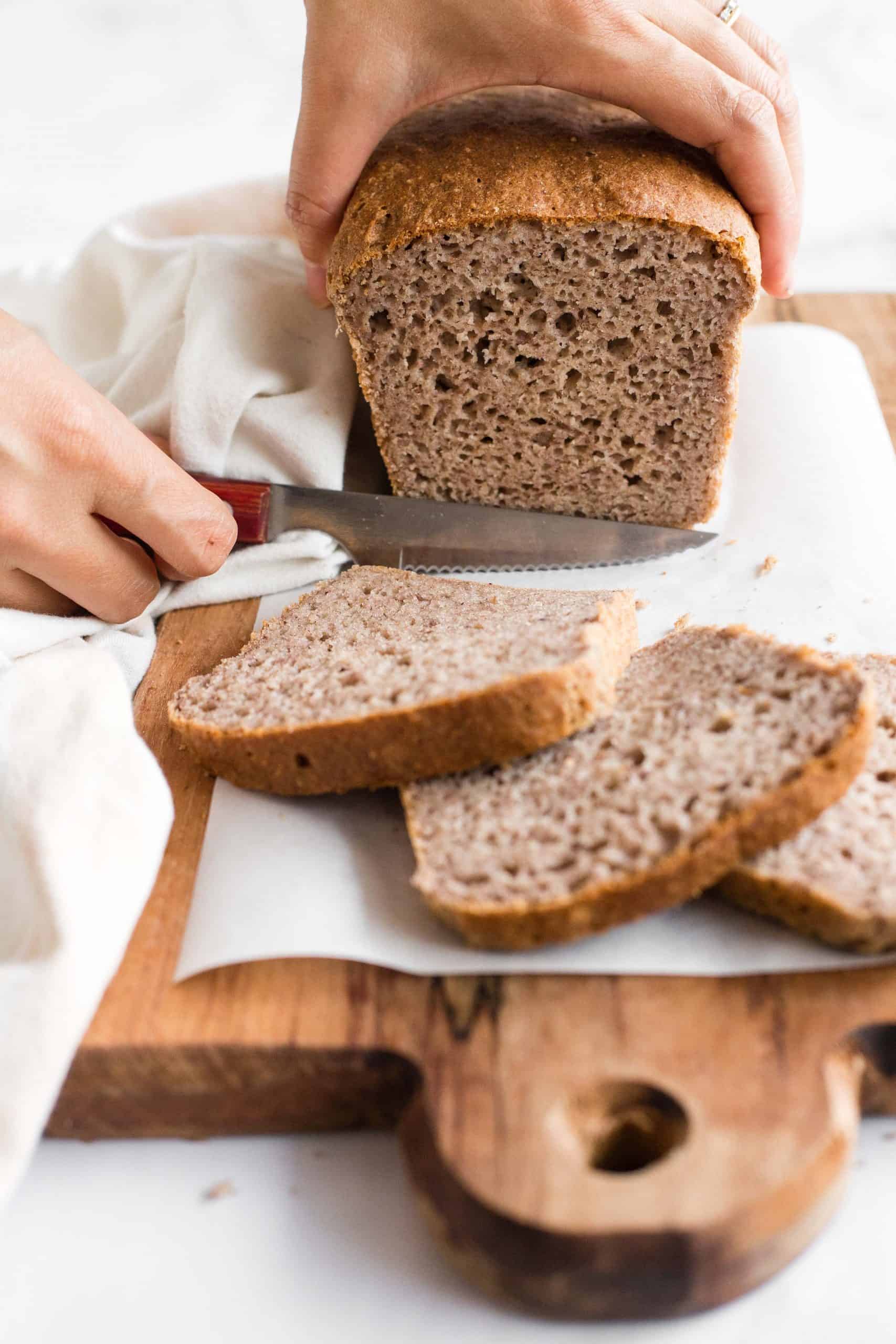 Slicing into a loaf of brown bread.