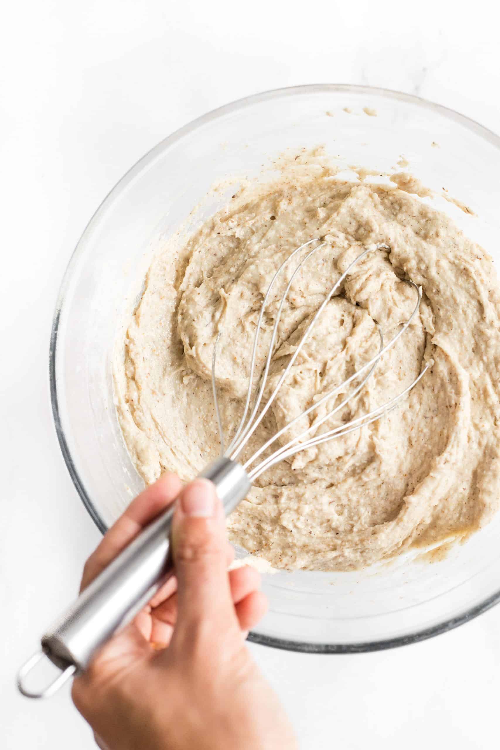 Mixing bread dough in a glass bowl.