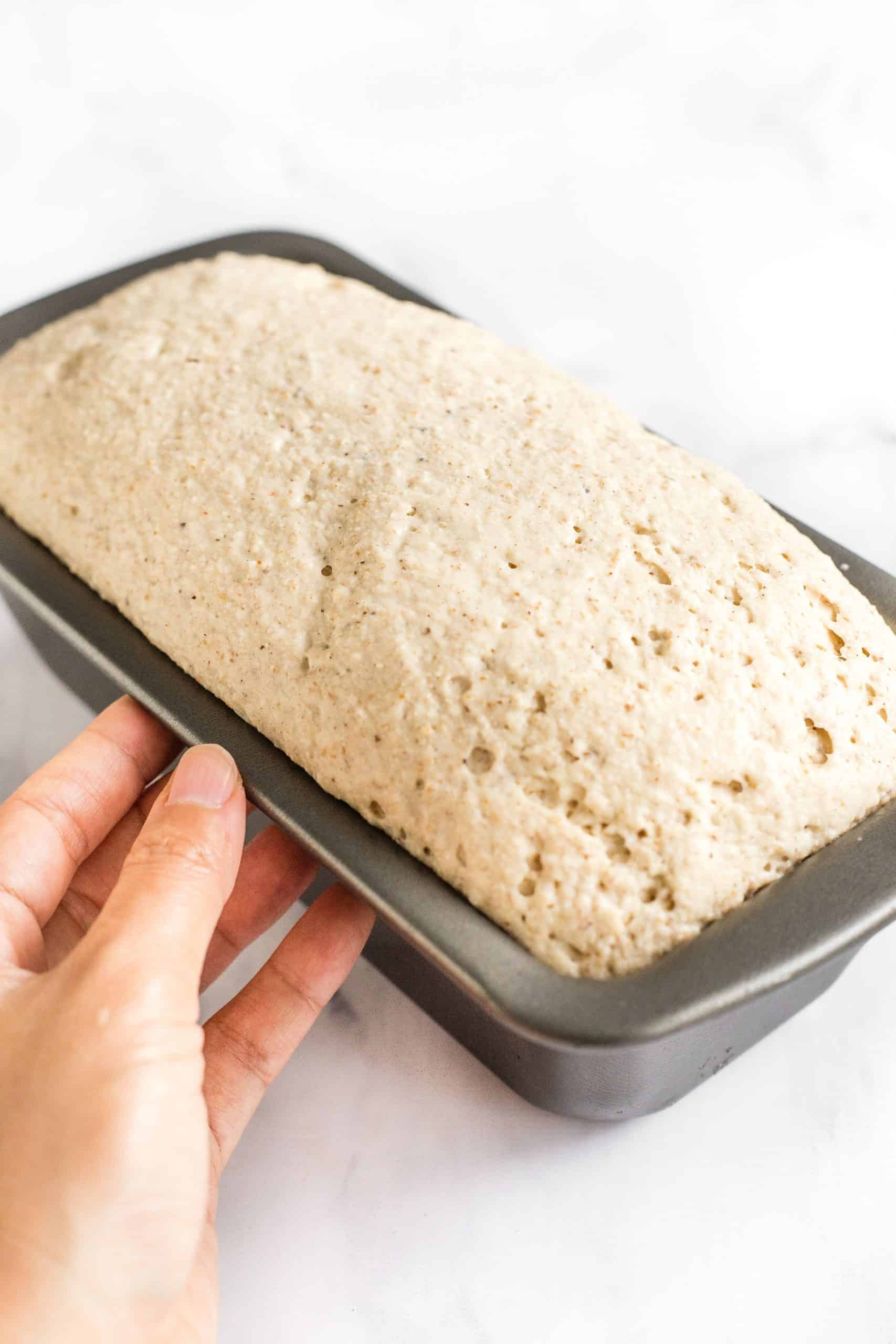 Holding a pan with unbaked bread dough.