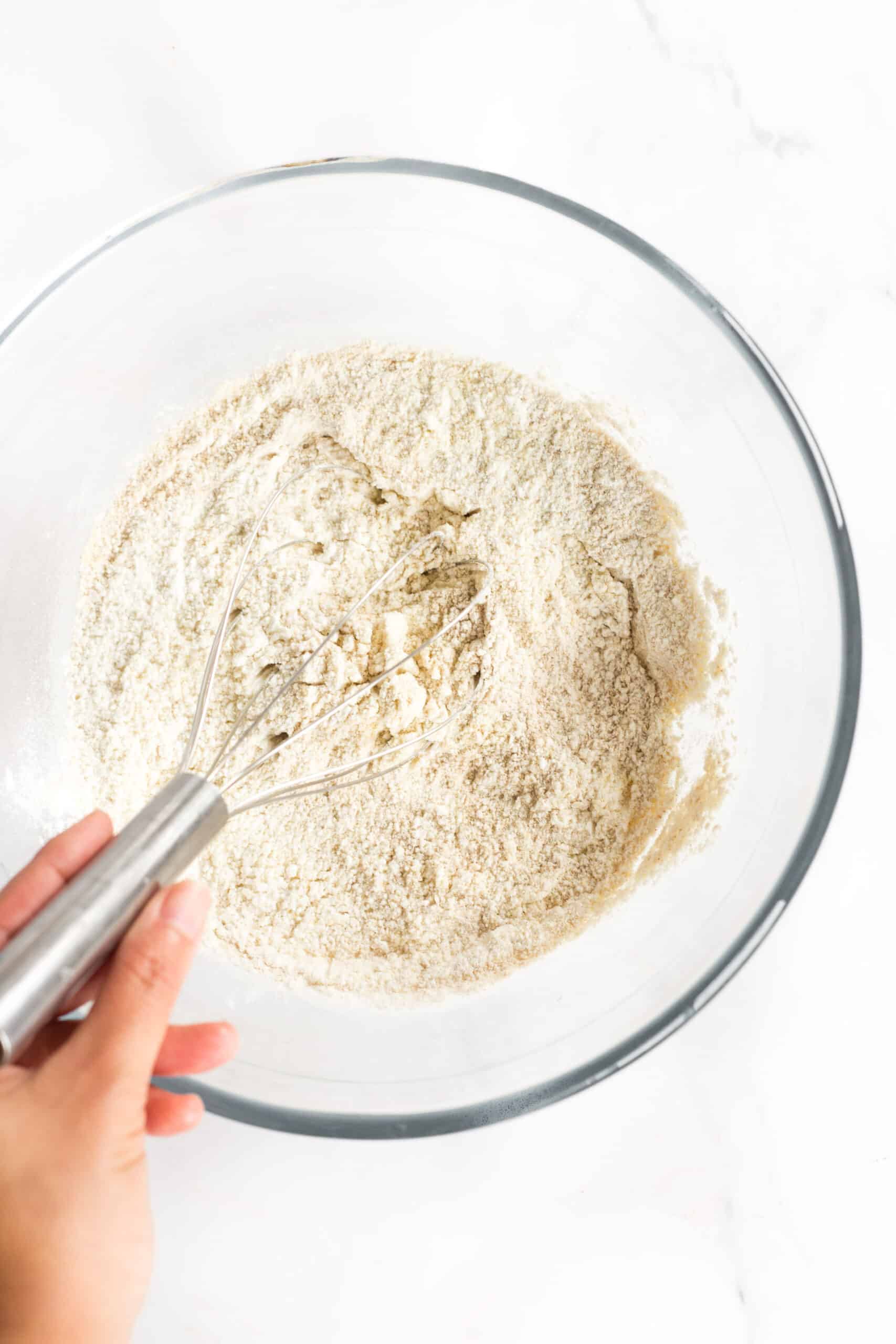 Whisking flour mixture in a glass bowl.