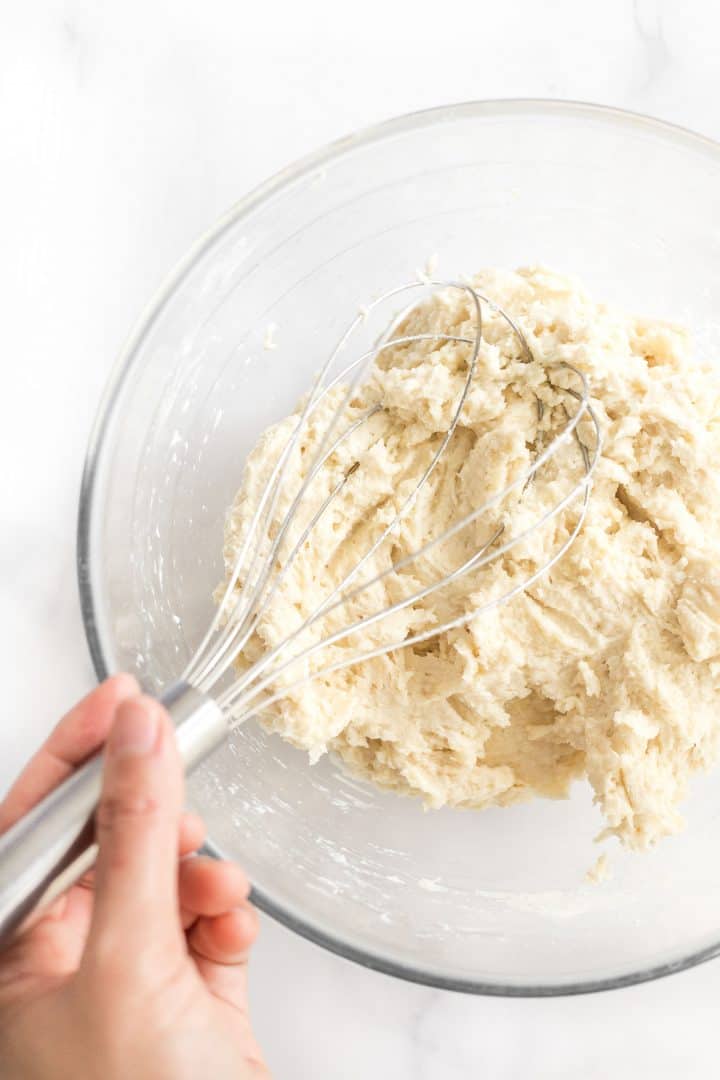 Bread dough in glass mixing bowl.