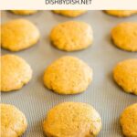 Pumpkin cookies on parchment-lined baking sheet.