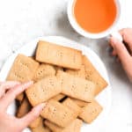 Hand reaching for sorghum graham crackers on plate