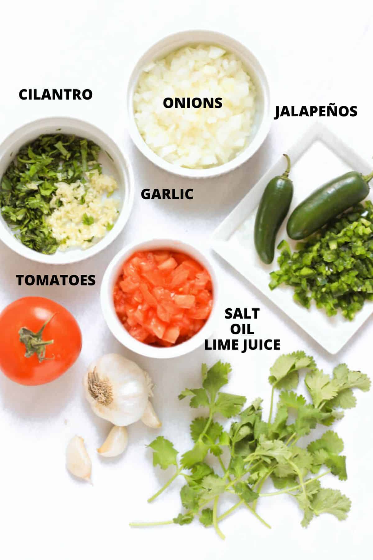 Ingredients for pico de gallo recipe laid out on marble board.