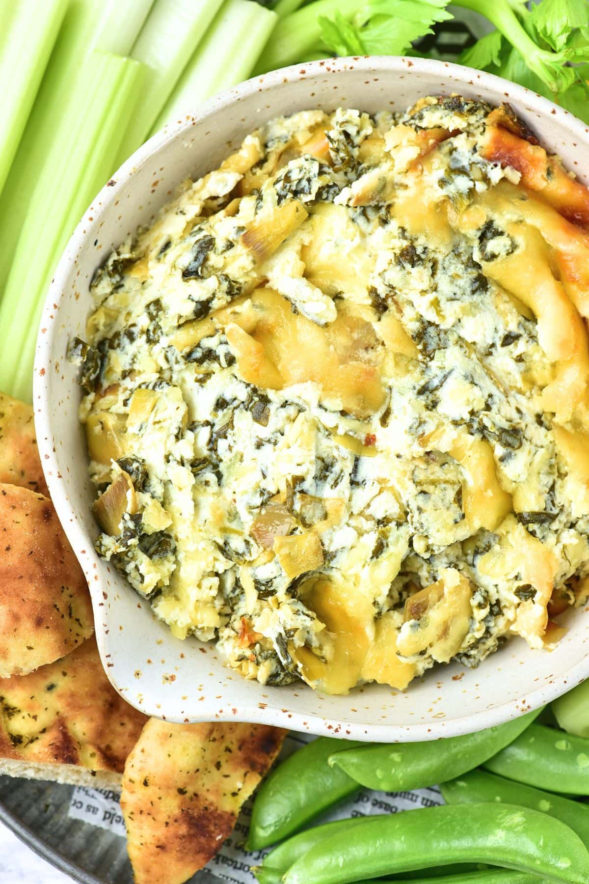 Top down view of bowl of creamy spinach artichoke dip.