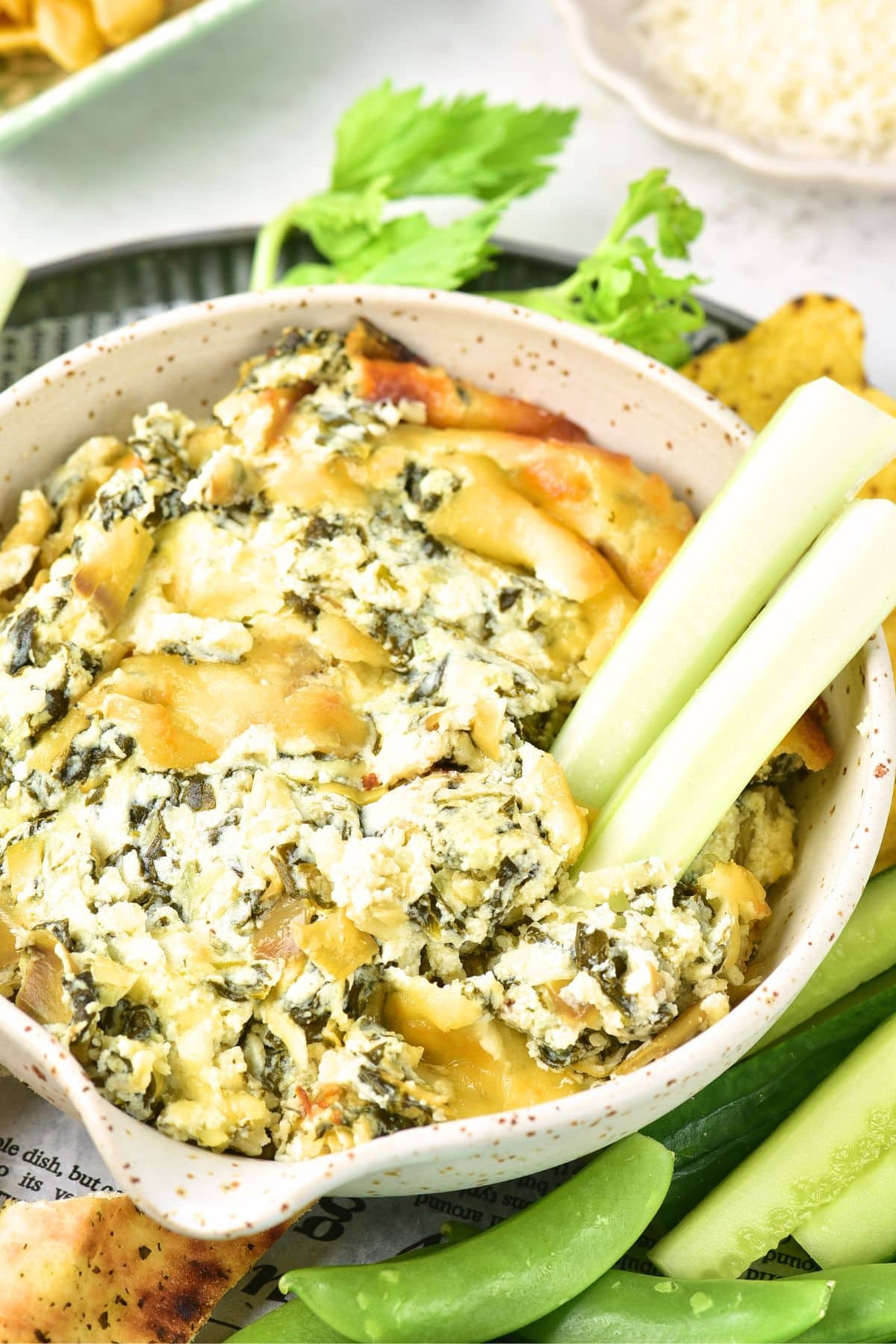 Celery sticks in a bowl of artichoke dip