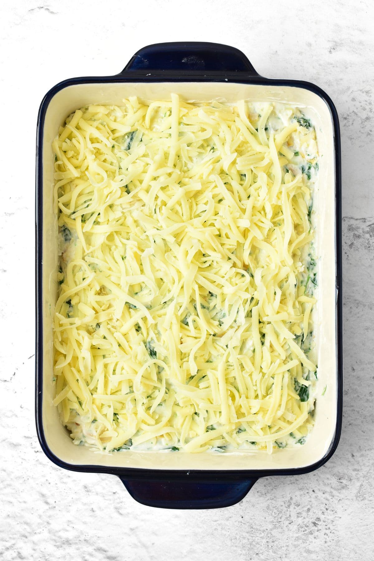 Shredded mozzarella on top of spinach mixture