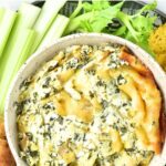 Top down view of spinach and artichoke dip with vegetable cruditées.