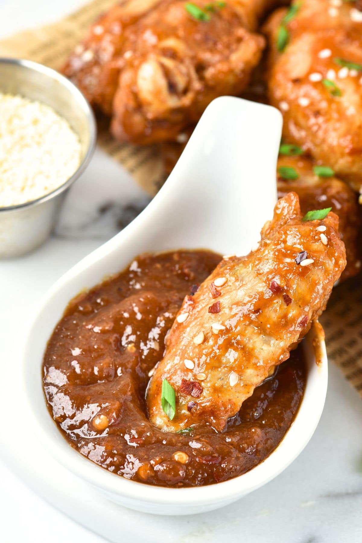 Dipping a chicken wing into brown sauce