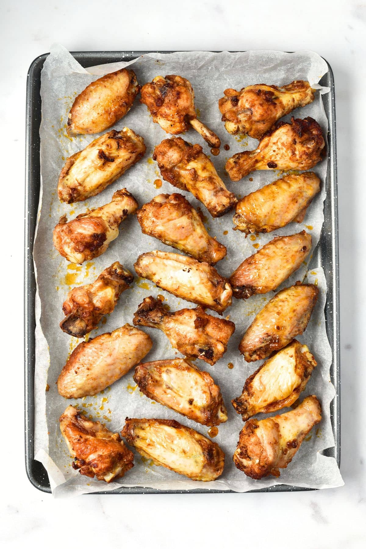 Baked chicken wings on parchment-lined baking sheet